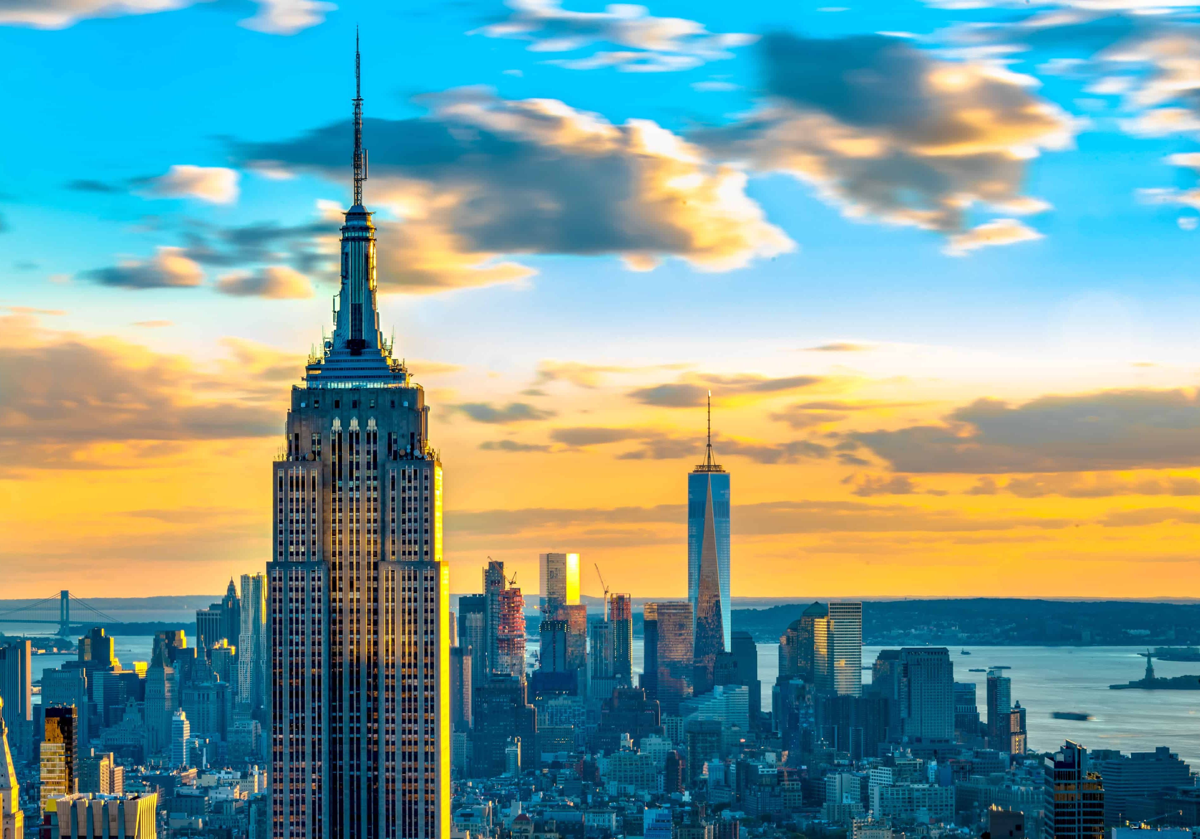 New York landmarks and attractions: Empire State building with One World Trade Center in the distant background. The two buildings represent architecture of two different eras.

One World Trade Center is the tallest building in New York while the Empire State Building is the third tallest building.